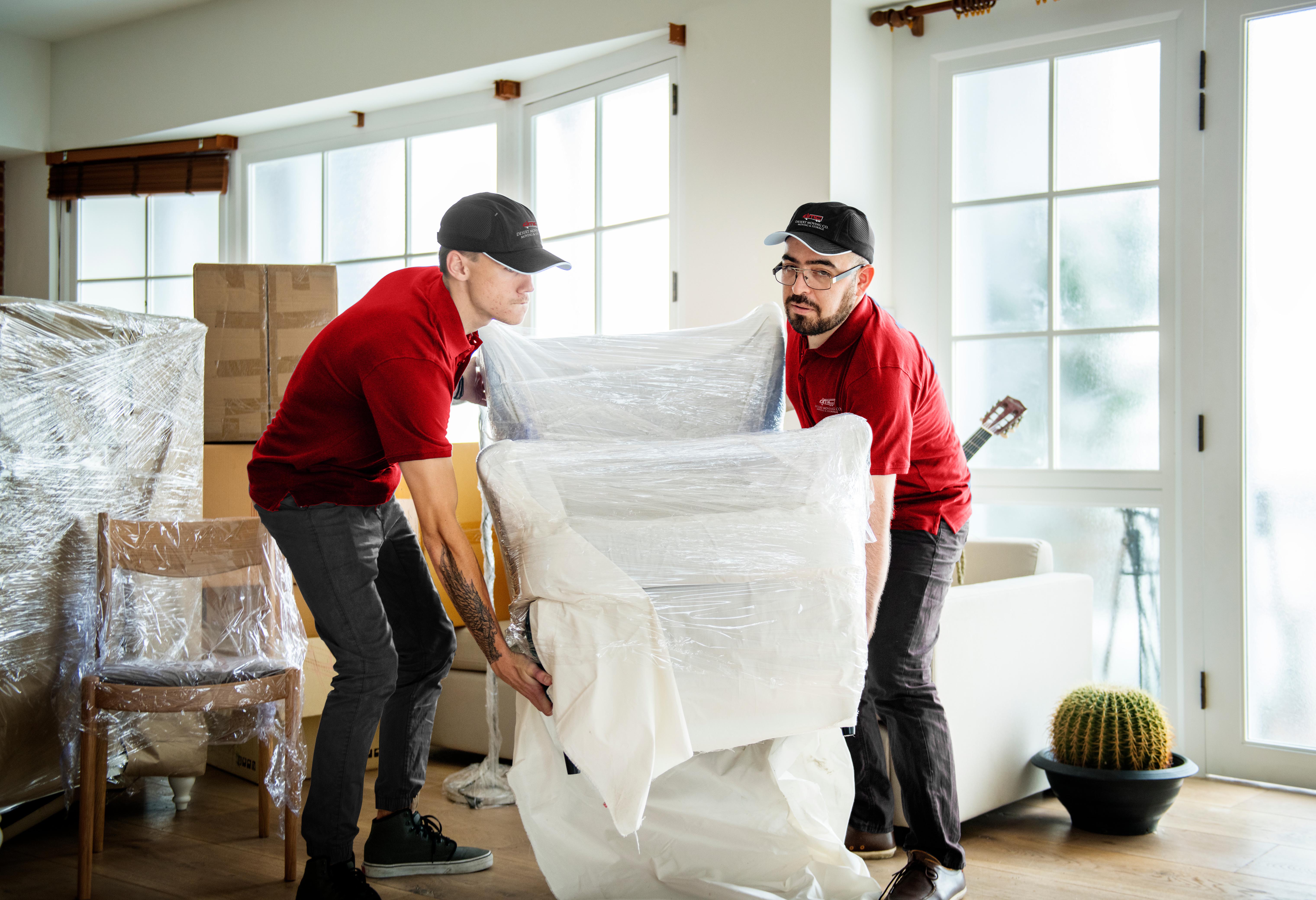 Desert Moving crew carefully wrapping sofa in protective plastic